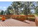 A wood deck with a brown stain has a view of the trees and landscape at 6449 S Jamaica Cir, Englewood, CO 80111