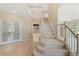 Grand two-story foyer with a staircase, light hardwood floors, and french doors at 6449 S Jamaica Cir, Englewood, CO 80111