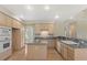 Bright kitchen with stainless steel appliances, hardwood floors, a large island, and seamless access to dining and living spaces at 6449 S Jamaica Cir, Englewood, CO 80111