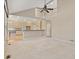 Spacious living area open to the kitchen, featuring high ceilings, large windows, and a view of the upper-level landing at 6449 S Jamaica Cir, Englewood, CO 80111