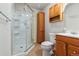 Bathroom featuring walk-in shower with sliding doors, vanity with storage, toilet, and neutral finishes at 22815 E Progress Ave, Aurora, CO 80015