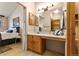 Bathroom with a vanity featuring a large mirror, wood cabinets, and access to the bedroom at 22815 E Progress Ave, Aurora, CO 80015