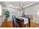 Elegant dining room with a modern chandelier, ample table space for gatherings, and warm hardwood floors at 22815 E Progress Ave, Aurora, CO 80015