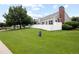 Charming home featuring a pristine lawn, white picket fence, and a view of a serene pond and lush greenery at 15555 E 40Th Ave # 36, Denver, CO 80239