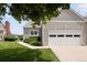 Home exterior featuring a garage and a walkway with rope details, neat landscaping, and scenic water view at 15555 E 40Th Ave # 36, Denver, CO 80239