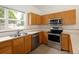This bright kitchen features stainless steel appliances and light wood cabinets at 15555 E 40Th Ave # 36, Denver, CO 80239