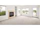 Bright living room with fireplace, built in shelving and access to a patio overlooking the lake at 15555 E 40Th Ave # 36, Denver, CO 80239