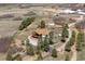 Expansive aerial view of a house and its land including an outbuilding and a white horse paddock at 3303 Wolfensberger Rd, Sedalia, CO 80135