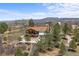 A high angle of a house nestled in a landscape with trees, and a partially visible winding driveway at 3303 Wolfensberger Rd, Sedalia, CO 80135