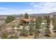 Overhead shot of home, with a walkout deck, set on land with mature trees, and a winding driveway at 3303 Wolfensberger Rd, Sedalia, CO 80135