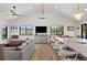 Open-concept living room featuring vaulted ceiling, views of the outdoors, and seating at both the living area and island at 3303 Wolfensberger Rd, Sedalia, CO 80135