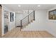Hallway featuring a modern staircase with black metal railing and a picture on the wall at 3303 Wolfensberger Rd, Sedalia, CO 80135