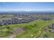 Aerial view showcases a golf course community, with homes nestled near green fairways and mountain views at 13025 Grant Cir # A, Thornton, CO 80241