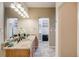 A well-lit bathroom showcasing a granite vanity and a walk-in closet for ample storage space at 13025 Grant Cir # A, Thornton, CO 80241