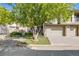 Home exterior featuring a two-car garage with a driveway and a lush green tree in the front yard at 13025 Grant Cir # A, Thornton, CO 80241
