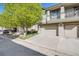 Home exterior featuring a two-car garage with a driveway and lush green tree in the front yard at 13025 Grant Cir # A, Thornton, CO 80241