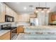 Bright kitchen boasts wooden cabinetry, stainless appliances, and a breakfast bar with a unique wood plank facade at 13025 Grant Cir # A, Thornton, CO 80241