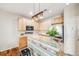 Charming kitchen featuring light wood cabinets, stainless steel appliances, and a unique distressed wood breakfast bar at 13025 Grant Cir # A, Thornton, CO 80241