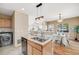 Open-concept kitchen with stainless steel appliances and unique, distressed wood breakfast bar overlooking the dining area at 13025 Grant Cir # A, Thornton, CO 80241