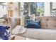 Living room close-up shows a comfortable couch with decorative pillows and bright light from large windows at 13025 Grant Cir # A, Thornton, CO 80241