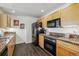 Functional kitchen with wood cabinets, granite countertops, stainless steel appliances, and sleek dark wood floors at 300 W 11Th Ave # 15C, Denver, CO 80204