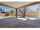 Covered backyard patio with a concrete slab, wooden beams, and view of a fenced yard with a mature tree at 2900 S Adams St, Denver, CO 80210