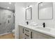 Bathroom with dual sinks, sleek black faucets, and a modern glass-enclosed shower with marble-look tile at 2900 S Adams St, Denver, CO 80210