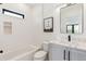 Stylish bathroom featuring a modern vanity with marble countertops, a bathtub, and a picture window at 2900 S Adams St, Denver, CO 80210
