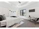Modern bedroom featuring a large window, neutral decor, a side chair and a black accent wall at 2900 S Adams St, Denver, CO 80210