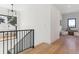 Bright upstairs hallway with wood floors, modern railing, and a view of a cozy seating area at 2900 S Adams St, Denver, CO 80210