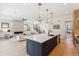 Open-concept living space with a fireplace, modern kitchen island with pendant lighting, and staircase at 2900 S Adams St, Denver, CO 80210