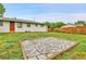 Backyard with grass, stone tile square, white house, and wood fence at 4680 Independence St, Wheat Ridge, CO 80033