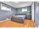 Bedroom features hardwood floors, grey walls, two windows, and closet with white sliding doors at 4680 Independence St, Wheat Ridge, CO 80033