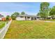 Wide angle of a home with a large lawn, a white picket fence, and a two car garage at 4680 Independence St, Wheat Ridge, CO 80033