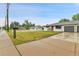 A home's exterior with a large front lawn, complemented by a driveway and a white picket fence at 4680 Independence St, Wheat Ridge, CO 80033