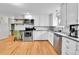 Well-lit kitchen with modern appliances, white cabinets, and hardwood floors providing a warm and inviting space at 4680 Independence St, Wheat Ridge, CO 80033