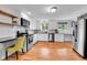 Modern kitchen featuring stainless steel appliances, white cabinets, and natural light with hardwood floors at 4680 Independence St, Wheat Ridge, CO 80033
