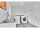 Laundry room features washer, dryer, sink, and ample space, with white walls and light grey tile at 4680 Independence St, Wheat Ridge, CO 80033