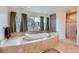 A luxurious bathroom featuring a corner soaking tub with decorative tile and scenic views at 3174 Soaring Eagle Ln, Castle Rock, CO 80109