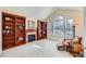 Cozy living room with a fireplace, built-in bookshelves, and a large window for natural light at 3174 Soaring Eagle Ln, Castle Rock, CO 80109