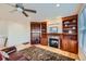 Living room with hardwood flooring, ceiling fan, fireplace and custom built-in shelving at 3174 Soaring Eagle Ln, Castle Rock, CO 80109