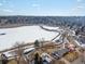 Unique aerial perspective showcasing the frozen lake and nearby residences, highlighting the property's tranquil setting at 12993 W 20Th Ave, Golden, CO 80401