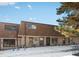Exterior view of a brick townhome with a brown roof and snow-covered yard at 12993 W 20Th Ave, Golden, CO 80401