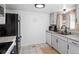 Well-lit kitchen featuring white cabinets, a black refrigerator, and stainless steel sink at 12993 W 20Th Ave, Golden, CO 80401