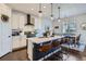 Eat-in kitchen with stainless appliances, white cabinets, island seating, and hardwood floors at 21038 E Quincy Pl, Aurora, CO 80015