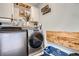 Well-organized laundry room featuring modern washer and dryer, shelving, and convenient folding space at 21038 E Quincy Pl, Aurora, CO 80015