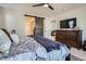 Comfortable main bedroom with a barn door leading to the bathroom and a large dresser with a TV at 21038 E Quincy Pl, Aurora, CO 80015