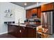 Modern kitchen with dark wood cabinets, stainless steel appliances, and a sleek black countertop island at 2001 Lincoln St # 920, Denver, CO 80202