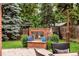Charming backyard fireplace with brick surround, nestled among mature trees and lush greenery, great for entertaining at 1332 S Lafayette St, Denver, CO 80210