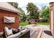 Cozy backyard patio with comfortable seating, outdoor fireplace, brick accents, and charming landscaping at 1332 S Lafayette St, Denver, CO 80210